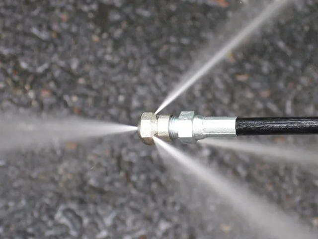 High-pressure hydro jetting nozzle clearing a sewer line